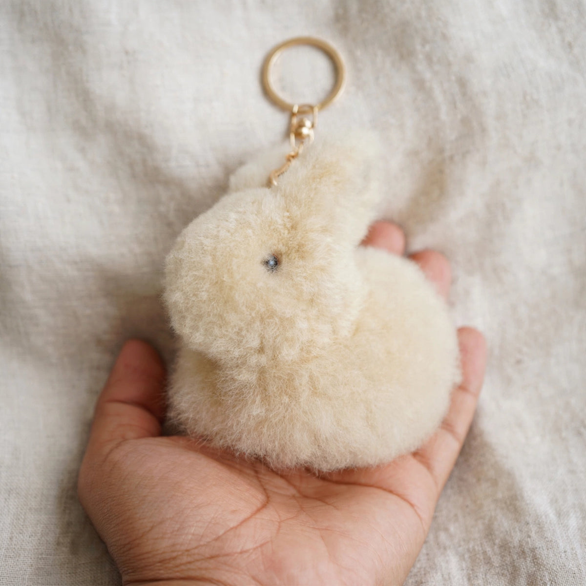 Alpaca fur bunny keychain held in hand to show size, about 6 inches